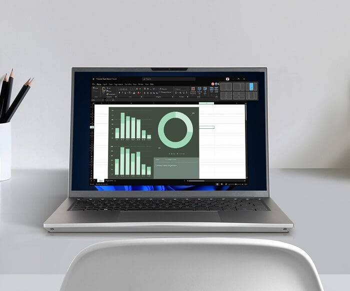 Image showing a laptop on an office desk with spreadsheets on its screen 