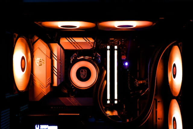 Close up of inside a PC showing its multitude of RGB fans and cooling system 