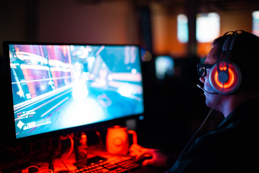 Image of someone sat at their desk playing a game on their gaming PC