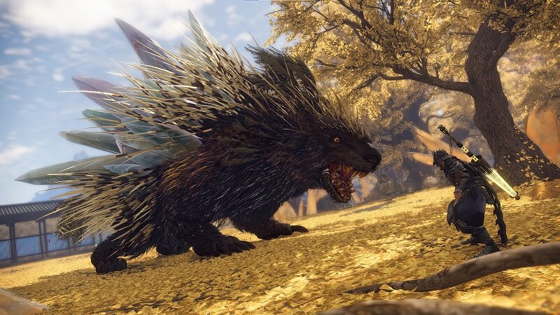 Gameplay capture image from Wild Hearts of the player character facing off against a giant porcupine looking creature amongst fallen yellow leaves