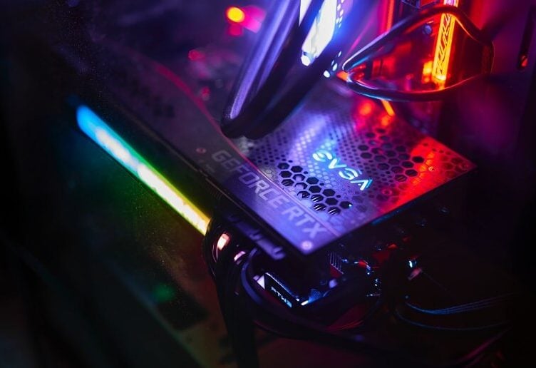 Close up photo of the GeForce RTX logo on an RTX 3050 GPU surrounded by colourful RGB lighting