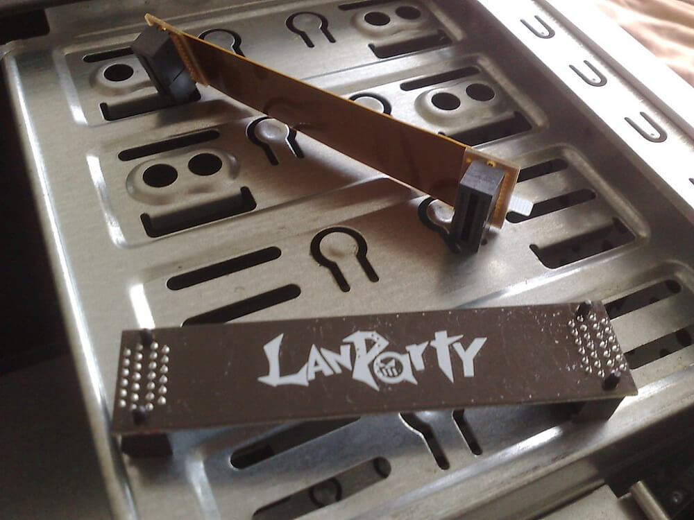 A photo of 2 old LanParty SLI connectors sat on a metal tray. 