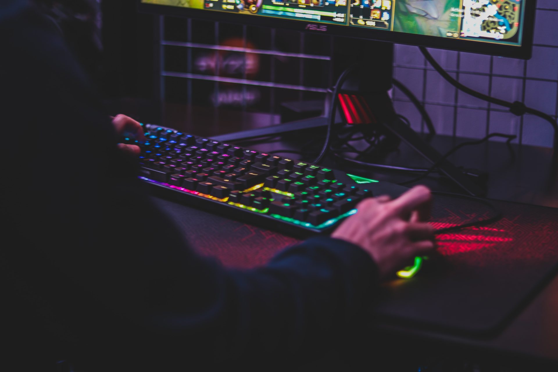 Photo of hands using an RGB keyboard and mouse for playing PC games