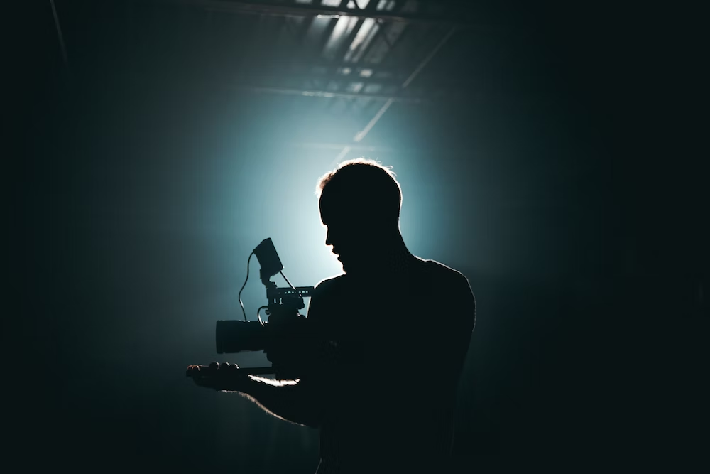 Videographer using a camera in a dimly lit room