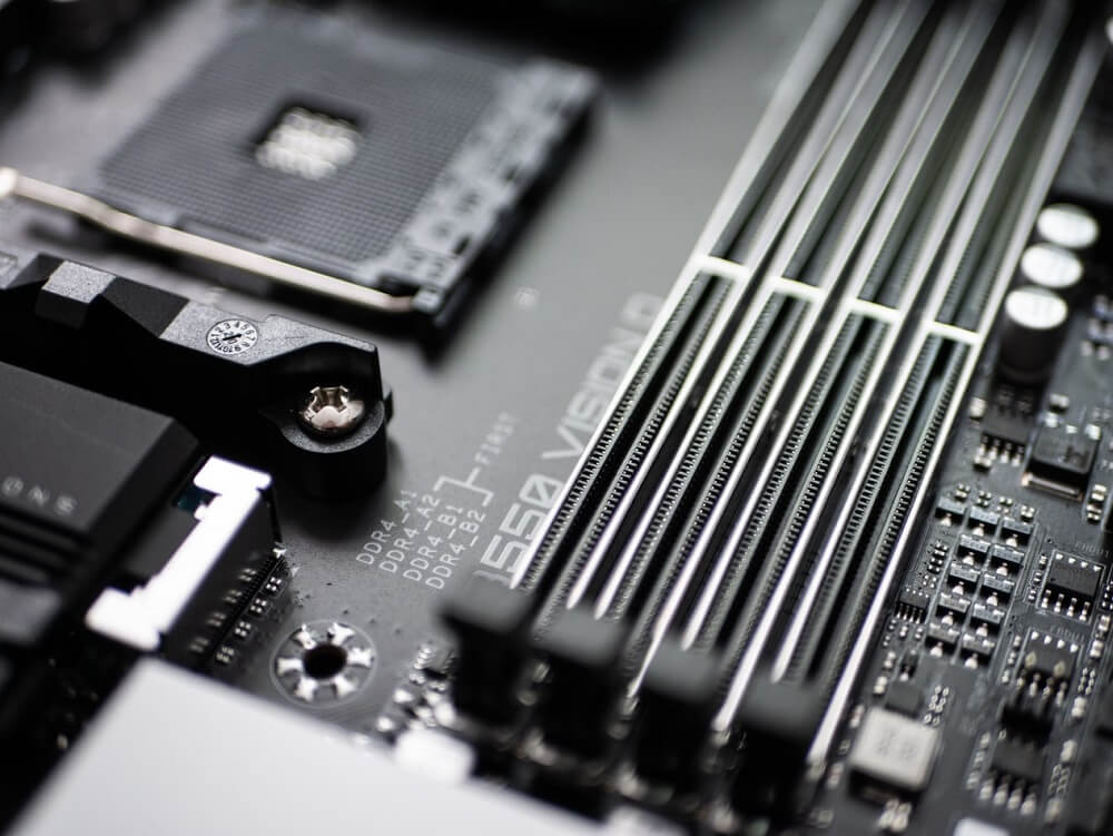 Close up image of 4 empty RAM slots on a motherboard