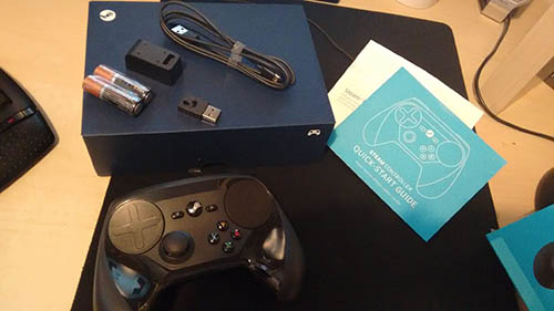 Photo of the contents of the Valve Steam controller box laid out on a desk, including batteries, cables and the instruction manual.