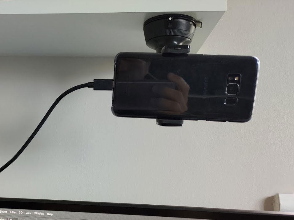 Image of the phone stuck above the monitor using a car phone mount