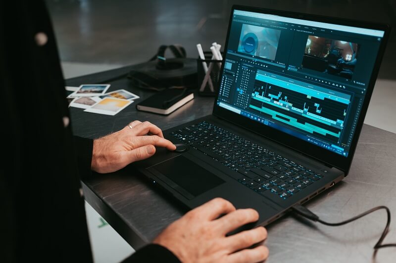 Close up of someone using a laptop for video editing